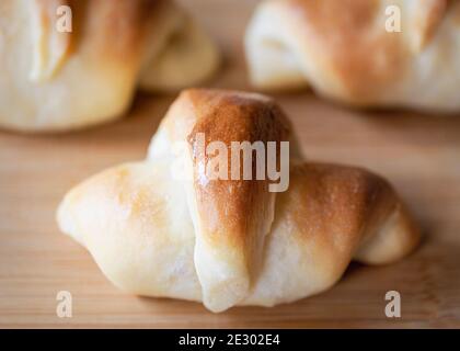Nahaufnahme einer Halbmondrolle auf einem Bambus-Holzschneidebrett. Stockfoto