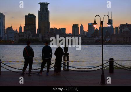 Beobachten des Sonnenuntergangs mit Blick auf den Bund in Shanghai. Freunde versammeln sich, um die Sonne verschwinden zu sehen. Stockfoto