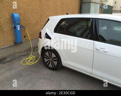 Stockholm, Schweden - 09. April 2015: Nahaufnahme der europäischen elektrischen modernen Auto Ladung auf der Straße, weißes Fahrzeug neben einem blauen öffentlichen Autos Ladegerät Stockfoto