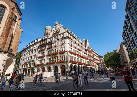 Kaufingerstraße, Einkaufsstraße und Fußgängerzone in Münchens Innenstadt in der Nähe des Marienplatzes, mit dem Schloss zum Schonen Turm. Stockfoto