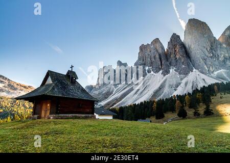 Blick auf die kleine Kirche der Glatschalm vor den Geislerbergen. Villnösser Tal, Dolomiten, Trentino-Südtirol, Italien. Stockfoto