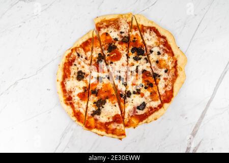 Pizza in Scheiben, Trüffelpilze mit Tomatensauce und Käse auf weißem Marmor Hintergrund Stockfoto