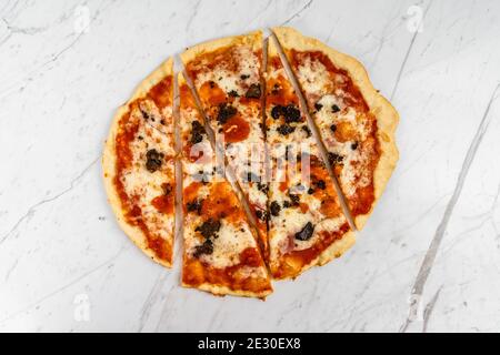 Pizza in Scheiben, Trüffelpilze mit Tomatensauce und Käse auf weißem Marmor Hintergrund Stockfoto
