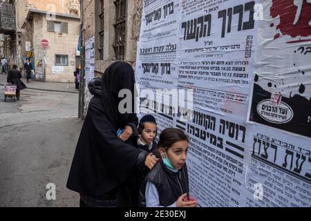 Ein Mitglied der sogenannten Haredi Burqa Sekte (jüdische religiöse Gruppe, in der ultra-orthodoxe jüdische Frauen behaupten, dass Bescheidenheit eine burka-artige Abdeckung des gesamten Körpers erfordert) geht mit ihren Kindern durch Mea Shearim, ein ultra orthodoxes Viertel in West-Jerusalem, Israel. Die Shalim, allgemein bekannt als der "Burka-Kult", ist eine der am meisten isolierten und verunglimpften Sekten in Israel, sogar unter der ultra-orthodoxen Bevölkerung des Landes. Stockfoto