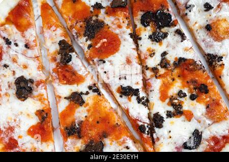 Pizza in Scheiben, Trüffelpilze mit Tomatensauce und Käse auf weißem Marmor Hintergrund Stockfoto