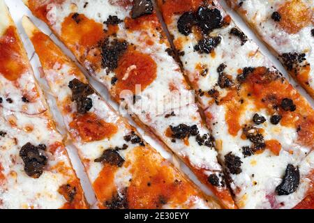 Pizza in Scheiben, Trüffelpilze mit Tomatensauce und Käse auf weißem Marmor Hintergrund Stockfoto