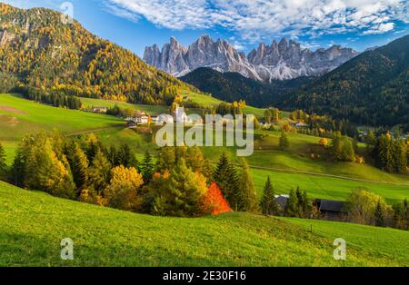 Blick auf einen schönen Sonnenuntergang auf dem Geislermassiv mit der Stadt und der Kirche St. Magdalena. Villnösser Tal, Dolomiten, Trentino-Südtirol, Italien. Stockfoto