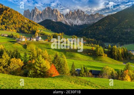 Blick auf einen schönen Sonnenuntergang auf dem Geislermassiv mit der Stadt und der Kirche St. Magdalena. Villnösser Tal, Dolomiten, Trentino-Südtirol, Italien. Stockfoto