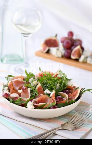 Rucola-Salat mit Parmaschinken, Blauschimmelkäse, Feigen, Trauben Stockfoto