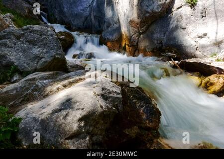 Bergbach zwischen riesigen Felsen in den Bergen in der Sommer Stockfoto