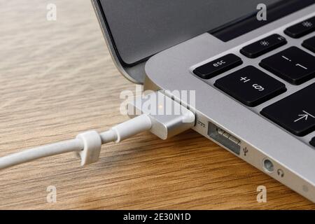 Der MagSafe magnetisch angebrachte Stromanschluss an einem 2012 Apple MacBook Air Stockfoto