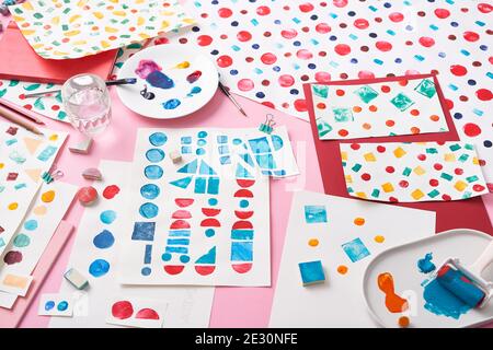 Von oben verschiedene geometrische Stempel und bunte Farbe aufgesetzt Tabelle neben Blatt Papier mit Ornamenten in der Werkstatt Stockfoto