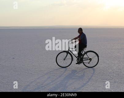 TUZ GOLU,AKSARAY,TÜRKEI-JULI 22:Unidentifizierter Mann, der ein Fahrrad am Salt Lake fährt.Juli 22,2017 in Tuz Golu,Aksaray,Türkei. Stockfoto