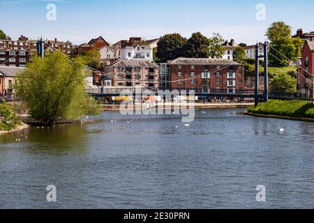 Ruhige Aussicht auf den Fluss exe, Exeter's Quay mit historischen Gebäuden und Fußgängerbrücke von exe Bridge South an einem sonnigen Frühlingstag, Exeter Quay, Exeter, Stockfoto