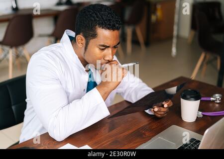 Nahaufnahme Porträt von afroamerikanischen schwarzen Mann Arzt analysiert Anamnese Krankheit Stockfoto