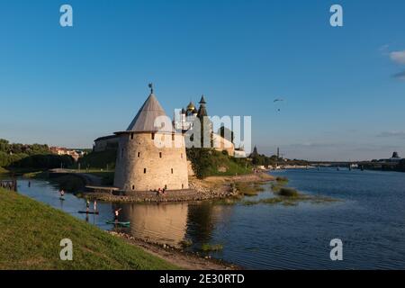 SUP-Surfer auf dem Velikaya-Fluss. Türme und Mauer des Pskov Kreml im Hintergrund. Pskow, Russland. Stockfoto