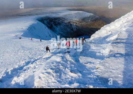 PEN-Y-FAN, WALES, UK - DEZEMBER 06 2020: Viele Wanderer und Wanderer genießen frischen Schnee auf dem Pen-y-Fan Berg im Brecon Beacons National Stockfoto