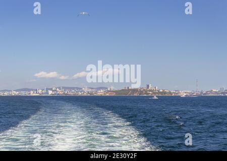 Wladiwostok Stadtbild aus der Ferne mit Booten und Meerblick mit Flug nach der Möwe an einem sonnigen Tag Stockfoto