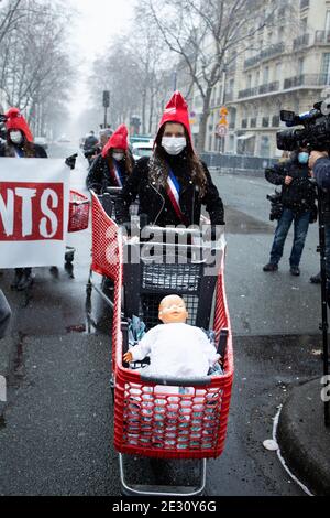 Demonstranten, die eine phrygische Mütze tragen und einen Einkaufswagen mit Baby-Puppen neben einen riesigen Babyballon schieben, während eines Protestes, den La manif pour tous, die konservative Aktivistengruppe 'La Manif Pour Tous' gegen den Bioethik-Gesetzentwurf zur medizinisch unterstützten Reproduktion (PMA - Procreation Medicalement Assistee) rief. Neben dem Gesundheitsminister am 16 2021. januar in Paris, Frankreich. Foto von Raphael Lafargue/ABACAPRESS.COM Stockfoto