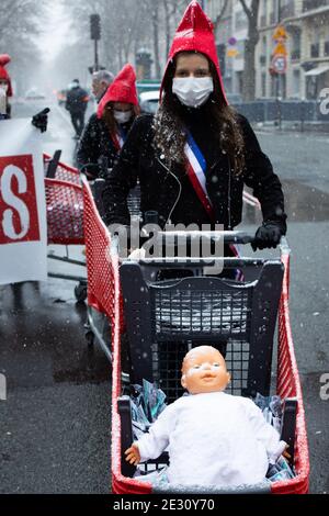 Demonstranten, die eine phrygische Mütze tragen und einen Einkaufswagen mit Baby-Puppen neben einen riesigen Babyballon schieben, während eines Protestes, den La manif pour tous, die konservative Aktivistengruppe 'La Manif Pour Tous' gegen den Bioethik-Gesetzentwurf zur medizinisch unterstützten Reproduktion (PMA - Procreation Medicalement Assistee) rief. Neben dem Gesundheitsminister am 16 2021. januar in Paris, Frankreich. Foto von Raphael Lafargue/ABACAPRESS.COM Stockfoto