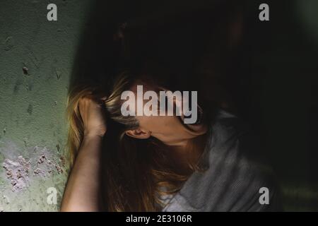 Allein Frau an den Haaren ziehen und schreien verzweifelt in Angst Und Frustration Stockfoto