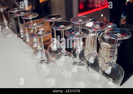 Gläser Wein. Gläser hängen über der Bar im Restaurant. Leere Gläser für Wein. Wein- und martini-Gläser im Regal über einem Barregal im Restaurant Stockfoto