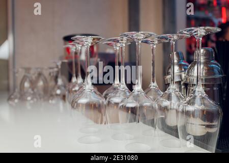 Gläser Wein. Gläser hängen über der Bar im Restaurant. Leere Gläser für Wein. Wein- und martini-Gläser im Regal über einem Barregal im Restaurant Stockfoto