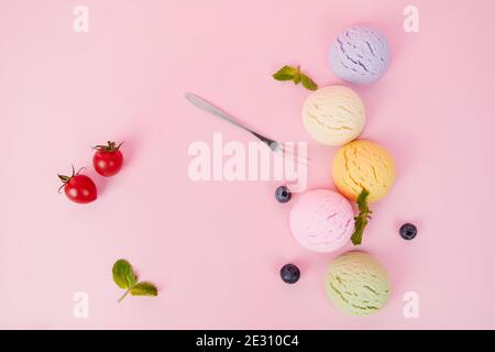Draufsicht auf verschiedene aromatisierte leckere Eisschaufeln und Beeren isoliert auf einem rosa Hintergrund Stockfoto