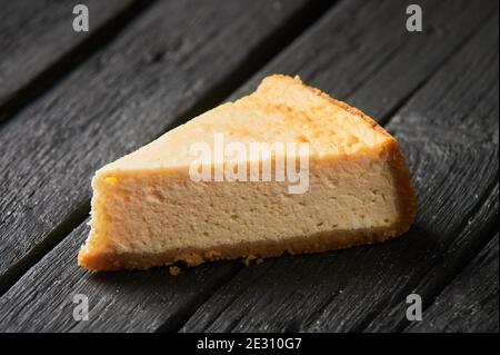 Nahaufnahme eines Stückes Karottenkuchen auf einem Teller mit kurzer Schärfentiefe. Kuchenscheibe auf einem Teller, mit dem ganzen Kuchen im Hintergrund Stockfoto