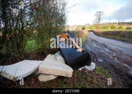 Fly - Kippen von unerwünschtem Hausmüll, einschließlich eines alten Sofas, am Straßenrand in der Nähe von Westerham in Kent, England. Stockfoto