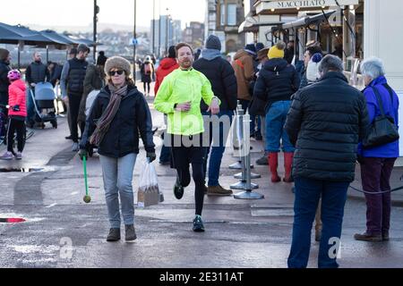 Portobello, Schottland, Großbritannien. 16. Januar 2021. Trotz der nationalen Sperre und der heutigen Verschärfung der Beschränkungen für das Servieren von Essen zum Mitnehmen und gesellschaftlichen Zusammenkünften, Portobello Promenade und Strand erwies sich als so beliebt wie immer am Samstagnachmittag mit vielen Mitgliedern der Öffentlichkeit, die dorthin zu Fuß und besuchen Cafés, die Essen und Getränke zum Mitnehmen anbieten. Keine Polizeipatrouillen waren offensichtlich. Iain Masterton/Alamy Live News Stockfoto