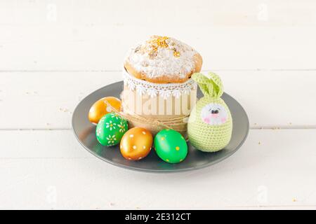 Arrangement Dekoration Frohe Ostern Urlaub Hintergrundkonzept. Ostercakeon ein Teller mit handgefertigten gestrickten Eiern. Pastellfarben. Stockfoto