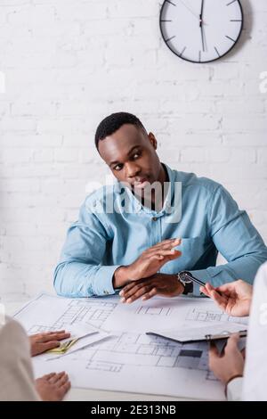 afroamerikanischer Geschäftsmann zeigt ablehnende Geste an Geschäftspartner geben Ihm Bestechung und Vertrag für die Unterzeichnung Stockfoto