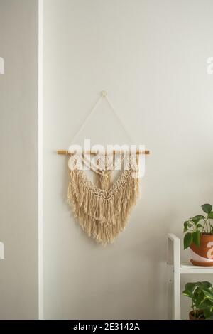 Schöne Boho Macrame Wandpaneel an einer weißen Wand hängen Stockfoto