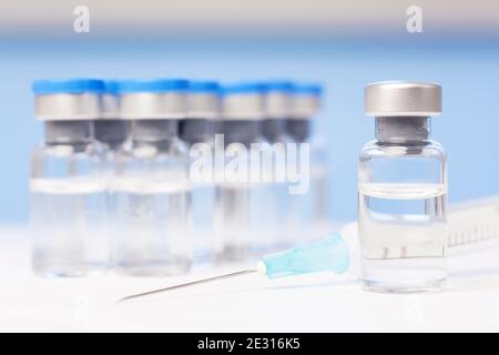 Fläschchen und Spritze mit Impfstoff gegen Covid-19 - Fokus auf Das Fläschchen im Vordergrund Stockfoto