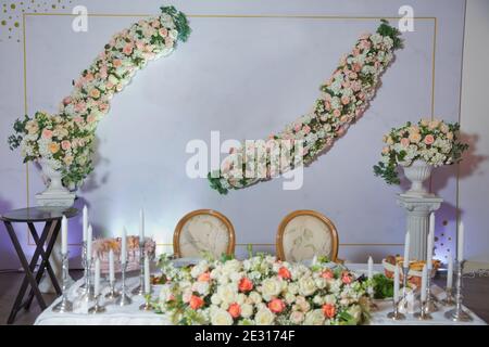 Hochzeitsbankett im Restaurant, Tische mit Blumen und Dekorationen, Kerzen. Tischset für Event-Party oder weiße Blumen Hochzeitsempfang. Stockfoto