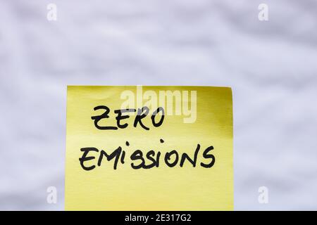 Emissionsfreie Handschrift Text Nahaufnahme isoliert auf gelbem Papier mit Kopierraum. Stockfoto