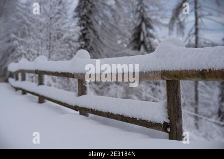 Winterlandschaft mit Holzzaun. Holzzaun mit Schnee bedeckt Stockfoto