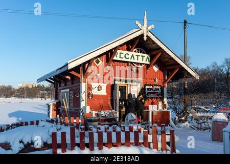 Café Regatta, eine kleine über 120 Jahre alte rote Blockhütte am Ufer von Taivallahti mit Sitzgelegenheiten im Freien, im Winter in Helsinki, Finnland Stockfoto