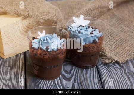 Keksklösse mit Schokolade und Frischkäse. Dekoriert mit mastistischen Schneeflocken. In der Nähe ist ein Leinentuch auf Kiefernbrettern. Stockfoto