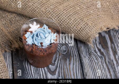 Keksklösse mit Schokolade und Frischkäse. Dekoriert mit mastistischen Schneeflocken. In der Nähe ist ein Leinentuch auf Kiefernbrettern. Stockfoto