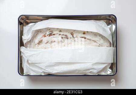 Weihnachtsstollenkuchen Christstollen isoliert auf weiß. Süßes, traditionelles Brot in einer Metallkiste verpackt, Draufsicht. Weihnachtsgeschenk von Dre Stockfoto