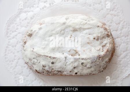 Christstollen Weihnachtsstollenkuchen auf weiß isoliert. Süßes deutsches traditionelles Brot mit Rosinen, Nüssen, Gewürzen, Trockenfrüchten und Puderzucker, Top V Stockfoto