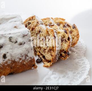 Weihnachtsstollen Kuchen süßes deutsches traditionelles Brot, Christstollen Scheiben auf weißem Hintergrund. Saisonales Dessert mit Rosinen, Nüssen, Gewürzen, getrockneten Fr. Stockfoto