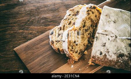 Christstollen Scheiben auf Holzhintergrund. Weihnachtsstollen Kuchen süßes deutsches traditionelles Brot, saisonales Dessert Nahaufnahme Stockfoto