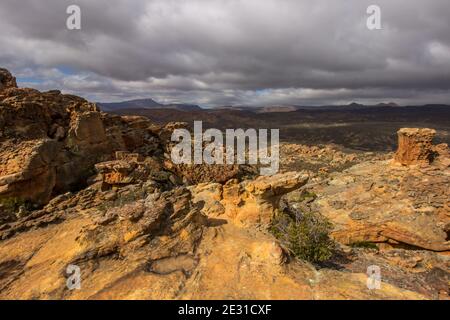 Blick über die zerklüftete Landschaft der Cederberg Mountains, Südafrika, mit einem sich aufsammelenden Sturm im Hintergrund, von den Stadsaal Höhlen aus gesehen Stockfoto