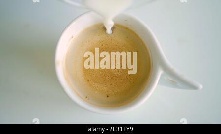 Bild mit einer Tasse mit aromatisierter Kaffee gemischt mit frisch Milch Stockfoto