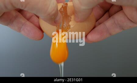 Nahaufnahme Bild mit Händen Brechen eines frischen Hühnereis In der Küche Vorbereitung der Morgen Omelett für das Frühstück Stockfoto