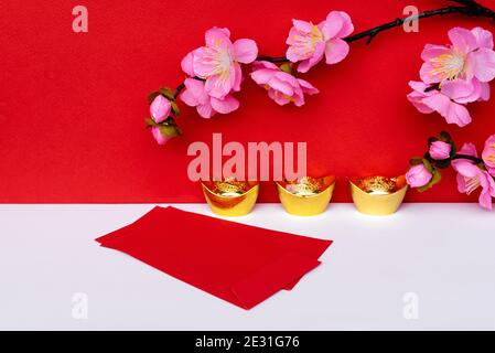 Sakura Blossom, Golden Ingot und Red Umschlag auf weißen und roten Hintergründen Stockfoto