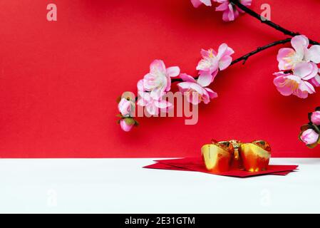 Sakura Blossom, Golden Ingot auf rotem Umschlag auf weißem und rotem Hintergrund Stockfoto